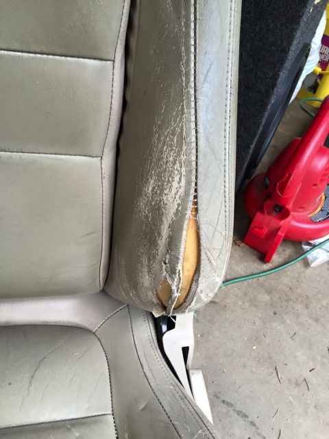 1995 Ford Probe - Close-up of a worn and torn gray leather car seat, showing exposed foam padding on the side bolster.