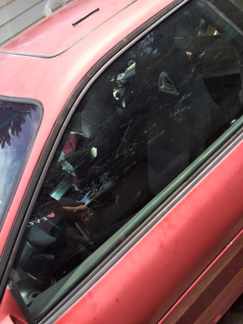 1995 Ford Probe - Close-up view of the driver's side door and window of a red 1995 Ford Probe. The window is partially open, revealing the interior with raci…