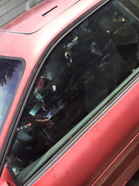 1995 Ford Probe - The interior of a red 1995 Ford Probe is visible through the driver's side window, which is partially open. The car has a sunroof and the i…