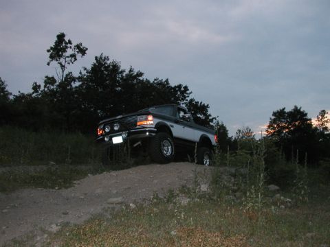 1994 Ford Bronco - This two-tone Ford Bronco is captured in a three-quarter front view as it ascends a dirt incline.