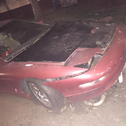 1995 Ford Probe - Front 3/4 view of a red 1995 Ford Probe showing damage to the front bumper and hood.