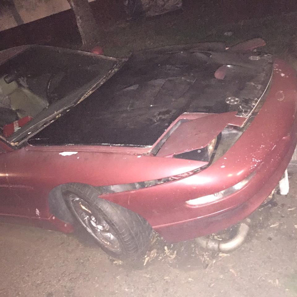 Red 1995 Ford Probe with damaged front end and hood