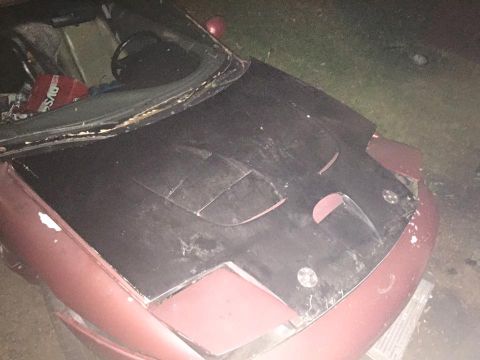 1995 Ford Probe - Front view of a red car with a black hood, showing damage and wear.