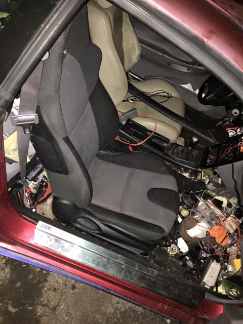 1995 Ford Probe - Car interior shows racing seats, a roll cage, and a lot of loose wires and parts.