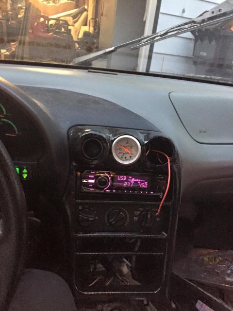 1995 Ford Probe - Interior view of a car's dashboard, an aftermarket stereo and a gauge.