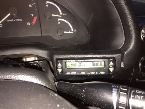 1995 Ford Probe - A close-up view of a digital air suspension controller mounted in the dashboard of a vehicle, displaying front and rear settings.