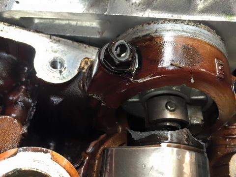 1995 Ford Probe - Engine components are visible with oil residue and a bolt in this close-up view.