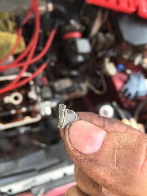 1995 Ford Probe - A close-up view of a small metal clip being held by a hand, with engine components visible in the blurred background.