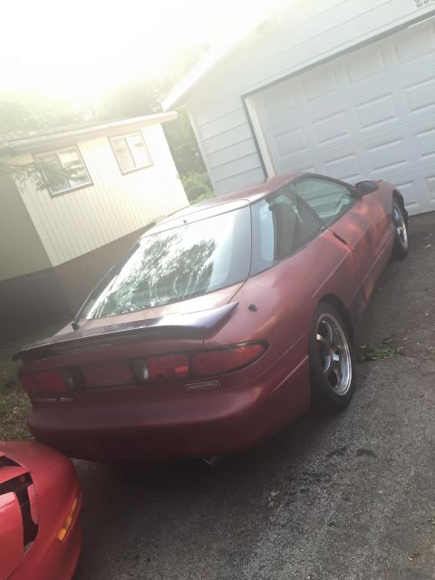 1995 Ford Probe - A red 1995 Ford Probe is parked in front of a garage.