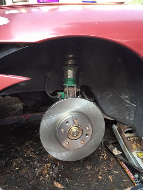 1995 Ford Probe - Close-up of a car's front brake rotor and suspension system, showing a new rotor installed.