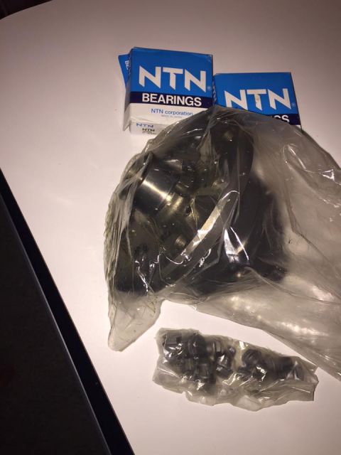 1995 Ford Probe - NTN bearings and a wheel hub assembly are laid out on a white surface.