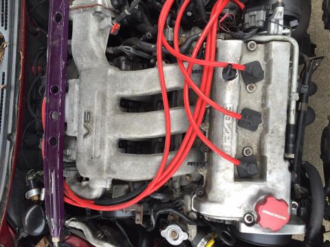 1995 Ford Probe - The engine features a V6 configuration with prominent red spark plug wires and visible 'MAZDA' branding on the valve cover.