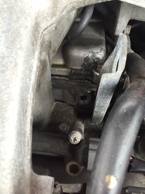1995 Ford Probe - Close-up view of an engine component with visible black sealant and a black hose attached.