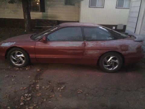1995 Ford Probe - Side view of a 1995 Ford Probe coupe showing red paint and primer patches.