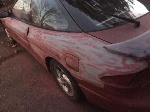1995 Ford Probe - This red car shows significant bodywork in progress, with primer visible on the rear quarter panel.