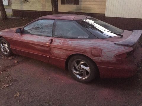 1995 Ford Probe - Side view of a 1995 Ford Probe showing primer spots on the body panels.