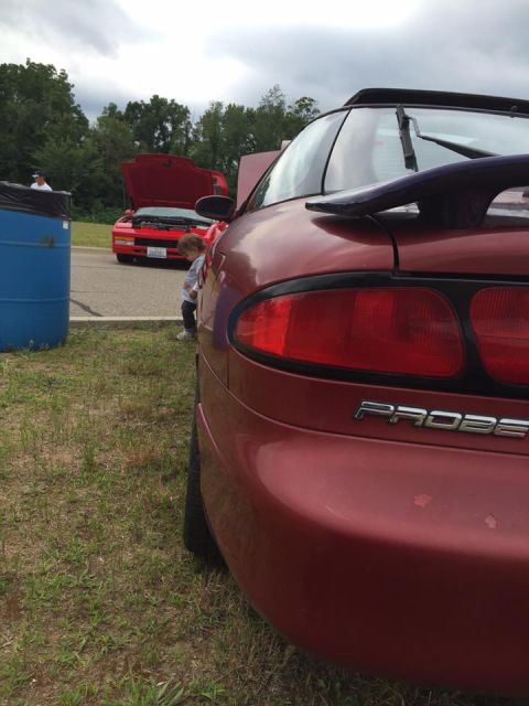 1995 Ford Probe - Rear view of a red 1995 Ford Probe, with another red car visible in the background.