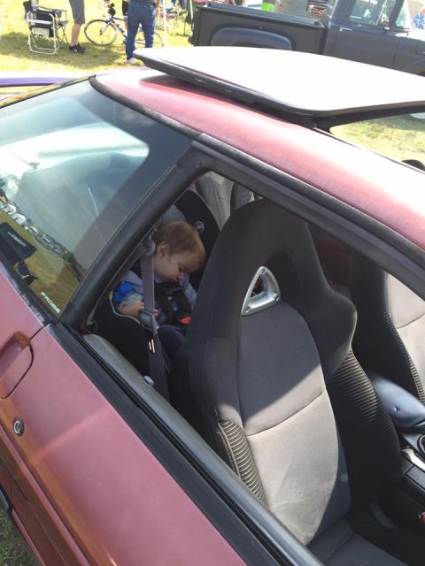 1995 Ford Probe - A child naps in a car seat, buckled in for safety, inside a vehicle with sporty bucket seats.