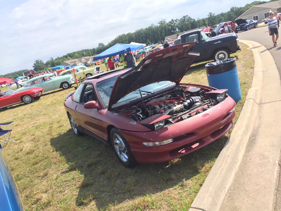 Red coupe with hood open, showing engine. Third-generation Ford Probe body style