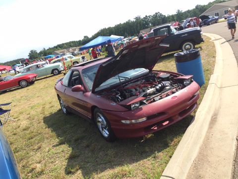 1995 Ford Probe - A red 1995 Ford Probe is displayed with its hood open at an outdoor car show.