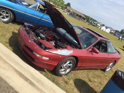 1995 Ford Probe - A red 1995 Ford Probe is displayed with its hood open, parked beside another vehicle.
