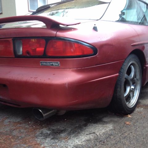 1995 Ford Probe - The rear of a red 1995 Ford Probe shows its spoiler, taillight, and exhaust pipe.