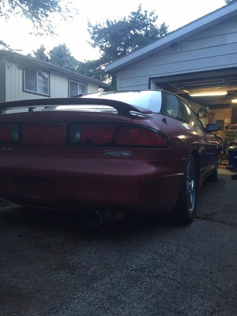 1995 Ford Probe - The rear of a red 1995 Ford Probe is visible, parked in front of a garage.