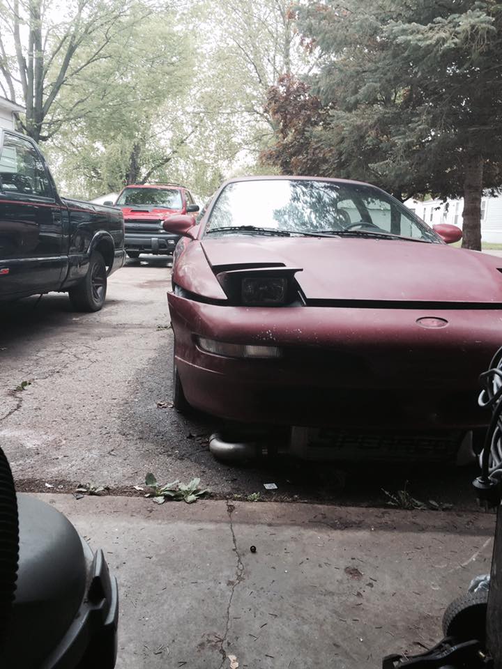 Red 1995 Ford Probe front view with pop-up headlights down