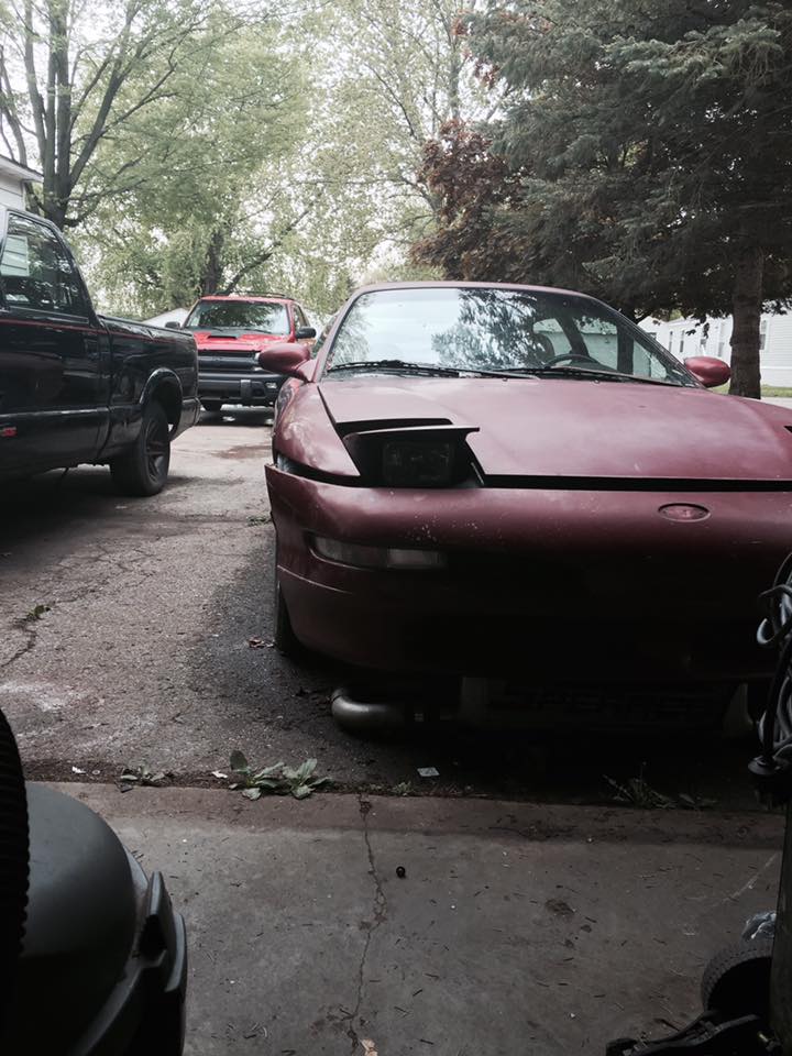Maroon 1995 Ford Probe with hood open, parked in a driveway.