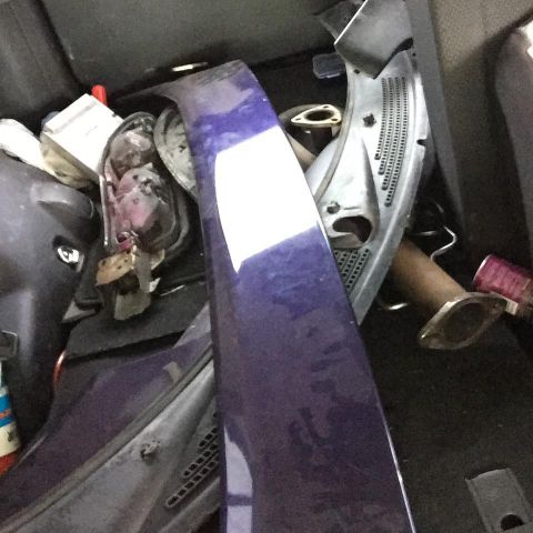 1995 Ford Probe - A close-up view of a purple car part, possibly a fender or spoiler, is positioned in the foreground. In the background, various car parts a…