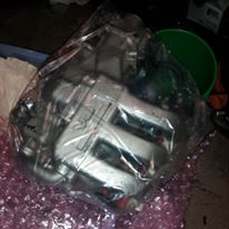 1995 Ford Probe - A silver-colored brake caliper is shown, still in its plastic packaging and resting on bubble wrap. The part appears to be new and unused.