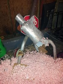 1995 Ford Probe - A muffler and a stop sign are covered in pink insulation in a cluttered storage area.