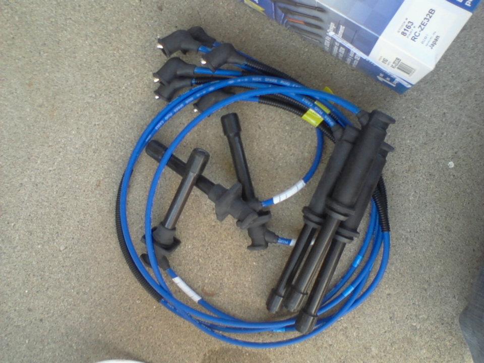 Blue spark plug wires and ignition coil boots with a product box.