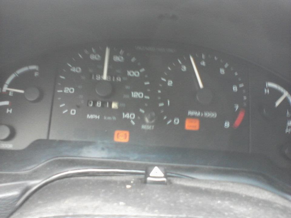 Car dashboard showing speedometer, tachometer, and odometer.