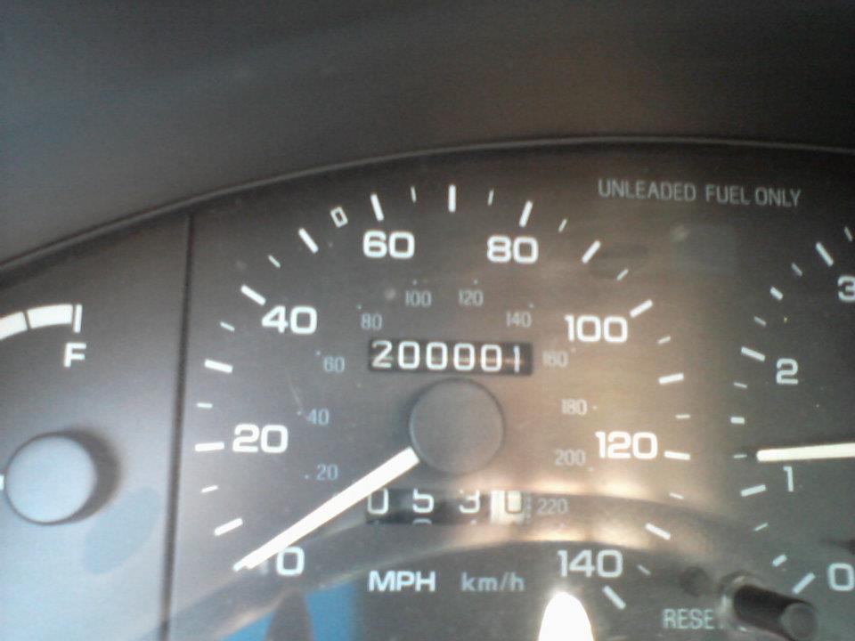 Car odometer showing 200001 miles and speedometer showing near 0 MPH.
