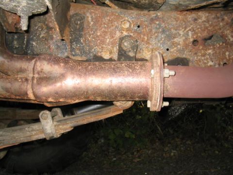 1979 Ford Bronco - Close-up view of rusted vehicle undercarriage components, including exhaust and suspension parts.