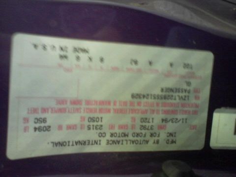 1995 Ford Probe - A close-up of a vehicle identification sticker showing manufacturing information and vehicle specifications. The sticker is affixed to the…