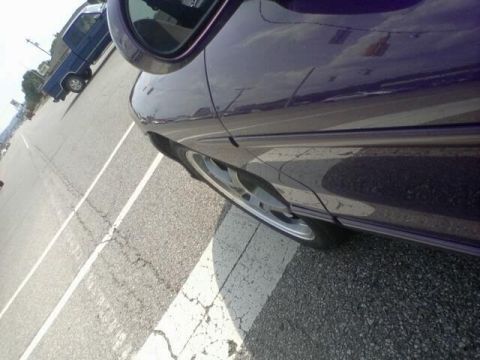 1995 Ford Probe - A purple car is parked next to a blue pickup truck on a sunny day.
