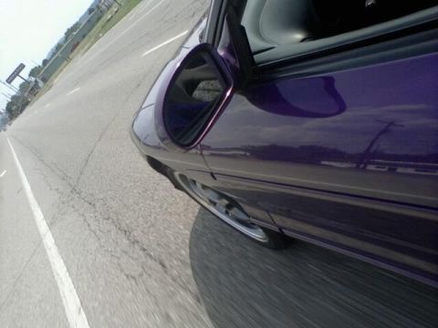 1995 Ford Probe - A purple car is seen from the side while driving on a highway.