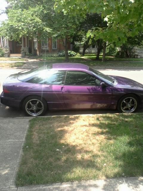 1995 Ford Probe - Side profile of a purple 1995 Ford Probe with aftermarket wheels parked on a residential street.