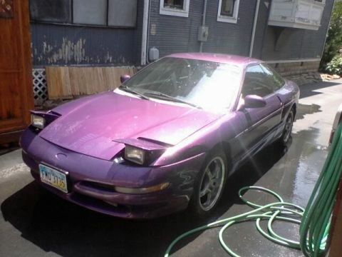 1995 Ford Probe - A purple 1995 Ford Probe is parked on a wet surface with a garden hose nearby.