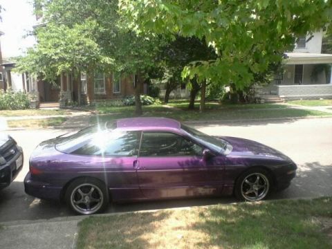 1995 Ford Probe - A purple 1995 Ford Probe is parked on a residential street next to another vehicle.