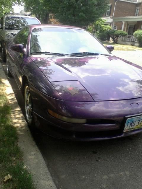1995 Ford Probe - A purple 1995 Ford Probe is parked curbside, with another vehicle visible behind it.