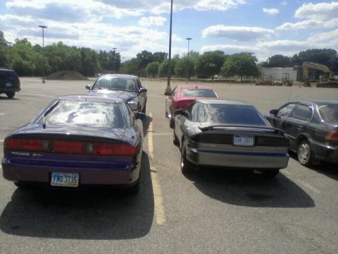 1995 Ford Probe - Two Ford Probe cars are parked in a lot. The purple one is a 1995 model.