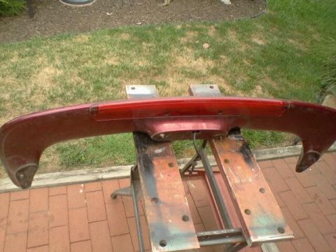 1995 Ford Probe - A red rear spoiler with a brake light is shown mounted on sawhorses.