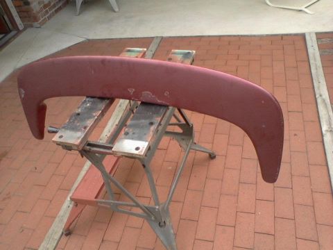 1995 Ford Probe - A maroon car spoiler rests on sawhorses outdoors, with visible paint damage.
