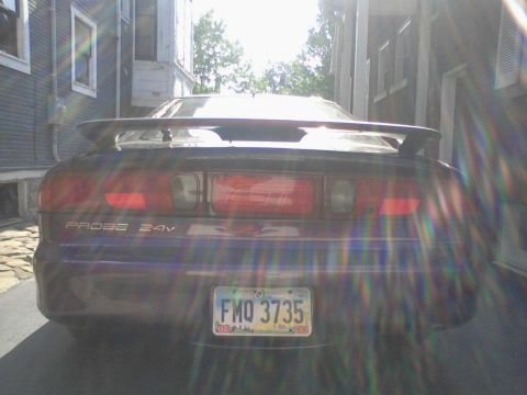 1995 Ford Probe - The rear of a dark purple 1995 Ford Probe is visible, a spoiler and an Ohio license plate.