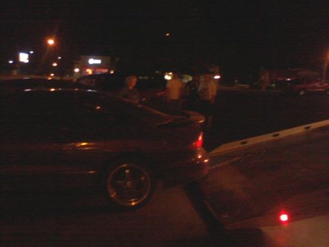 1995 Ford Probe - A red coupe is loaded onto a tow truck at night, with people visible in the background.