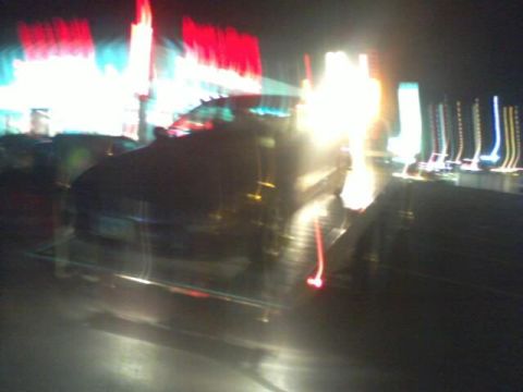 1995 Ford Probe - A dark, blurry photo shows a car at night with colorful, streaking lights in the background.