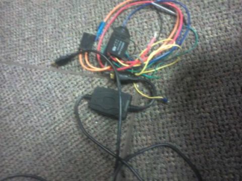 1995 Ford Probe - A tangled wiring harness with multiple black boxes and colorful wires is visible on a carpeted surface.